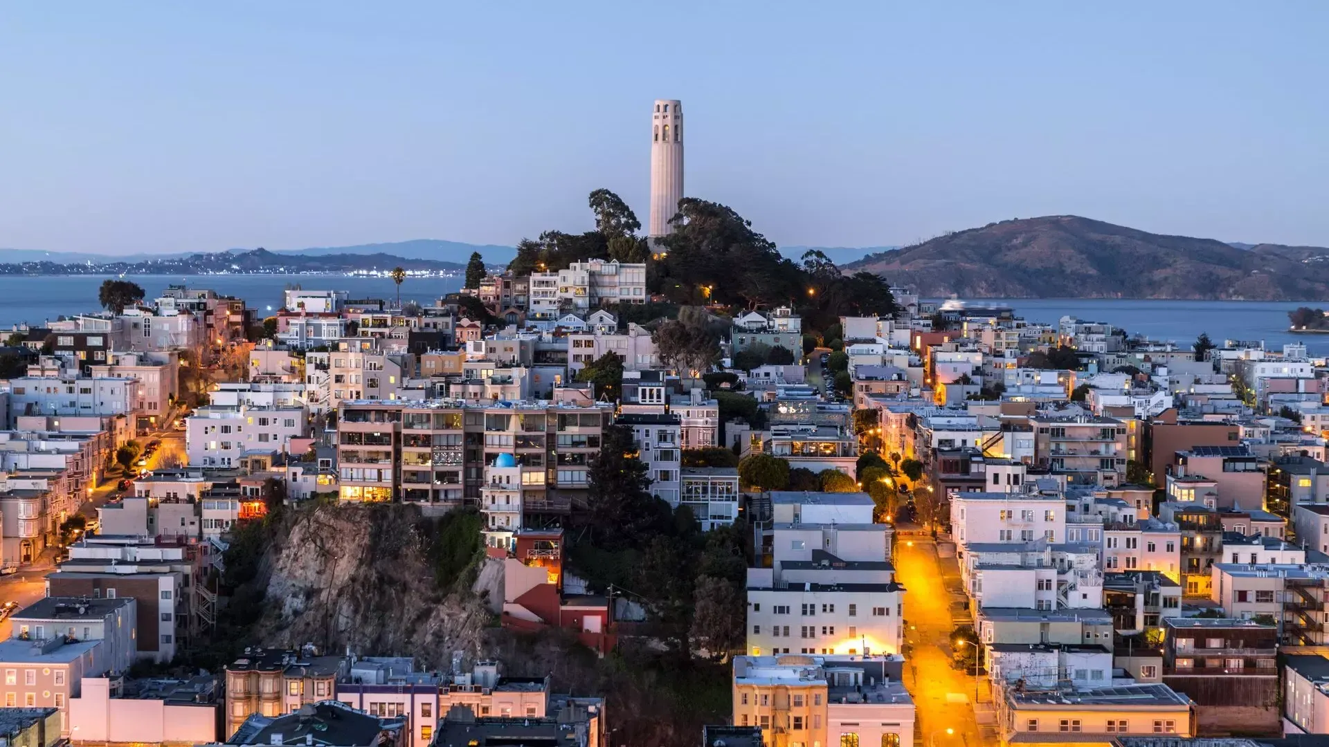 La Coit Tower de San Francisco au crépuscule, 前面是灯火通明的街道，后面是贝博体彩app湾区.