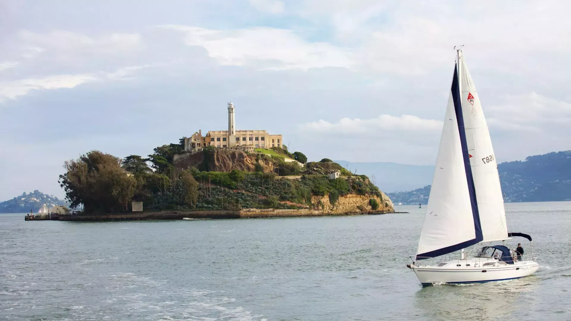 A sailboat passes in front of 阿尔卡特拉斯岛 Isl和 in San Francisco.