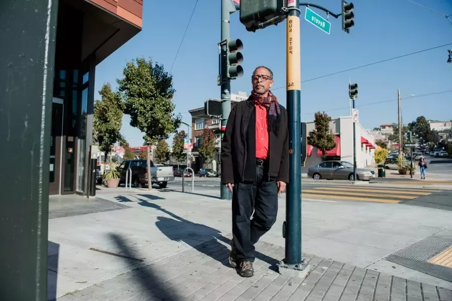 罗恩·莫尔特里·桑德斯 leaning against a pole.