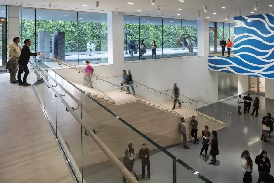 People walk up 和 down stairs in an airy atrium at the 贝博体彩app现代艺术博物馆 (SFMOMA).