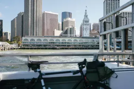 Fahrrad lehnt an einem Geländer, im Hintergrund das Fährgebäude.