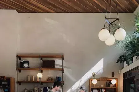 Man making coffee for woman at sunlight coffee-shop counter