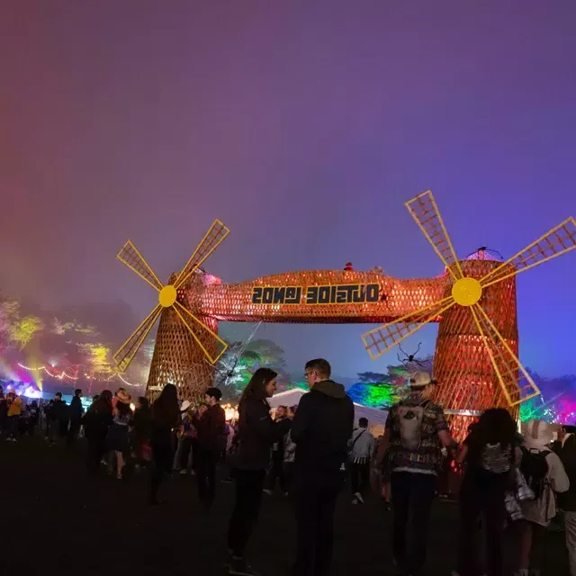 Una multitud de asistentes al festival son fotografiados de noche en medio de luces de neón en el festival de 音乐 Outside Lands en 贝博体彩app.