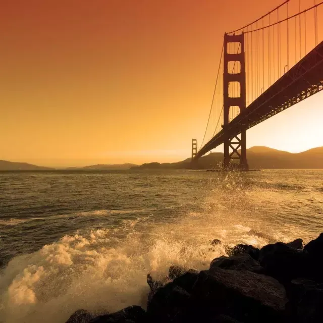 Les vagues s'écrasent près de Fort Point, sous le 金门大桥, au coucher du soleil.