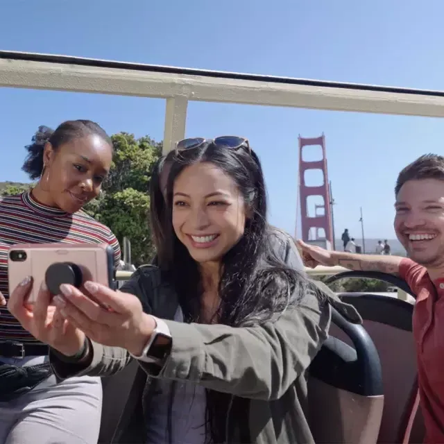 A group of visitors take a selfie on a bus tour near the Golden Gate Bridge. 贝博体彩app，加州.